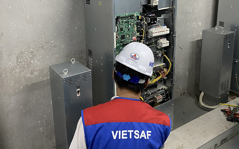 Kiểm định viên đang kiểm tra tủ điện điều khiển được đặt trên phòng máy của thang